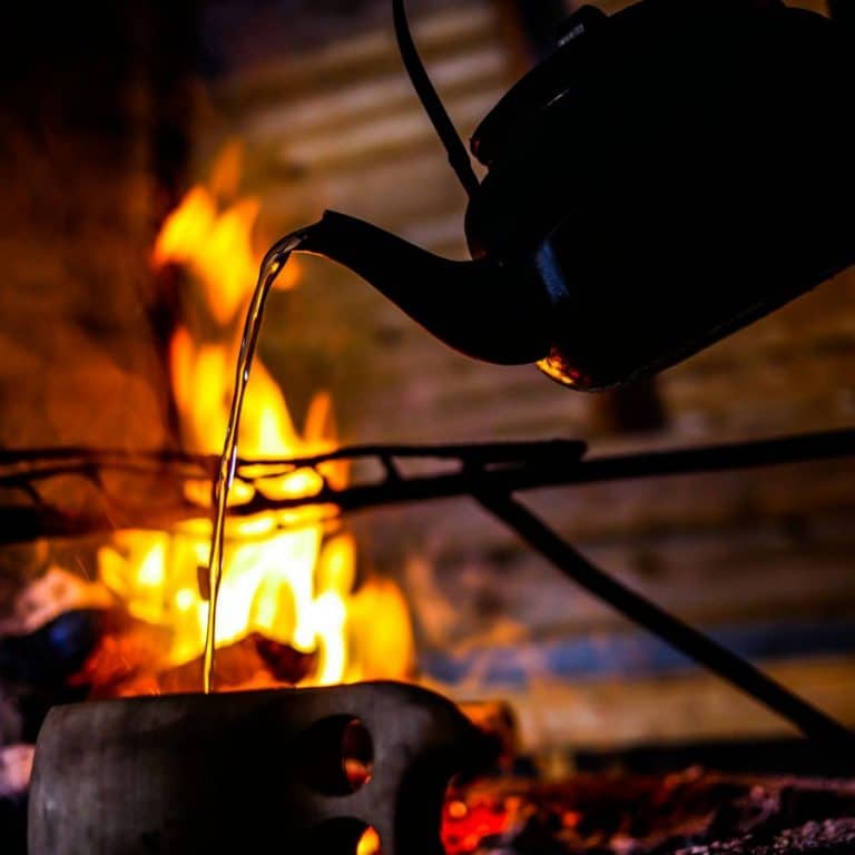 Brewing coffee by the open fire in a secret hideaway in Ylläs